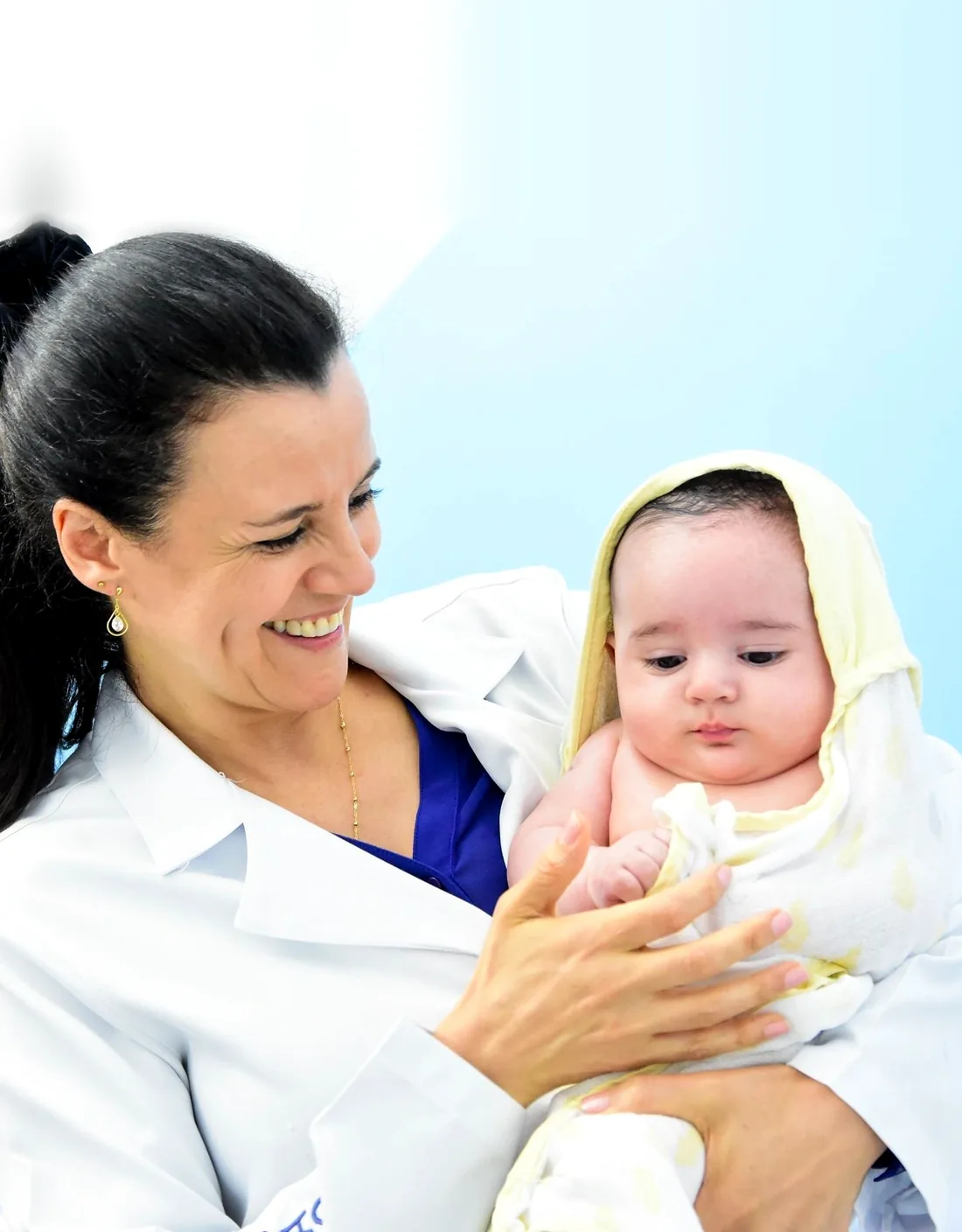 Enfermeira Mari Araujo sorrindo com um bebê no colo